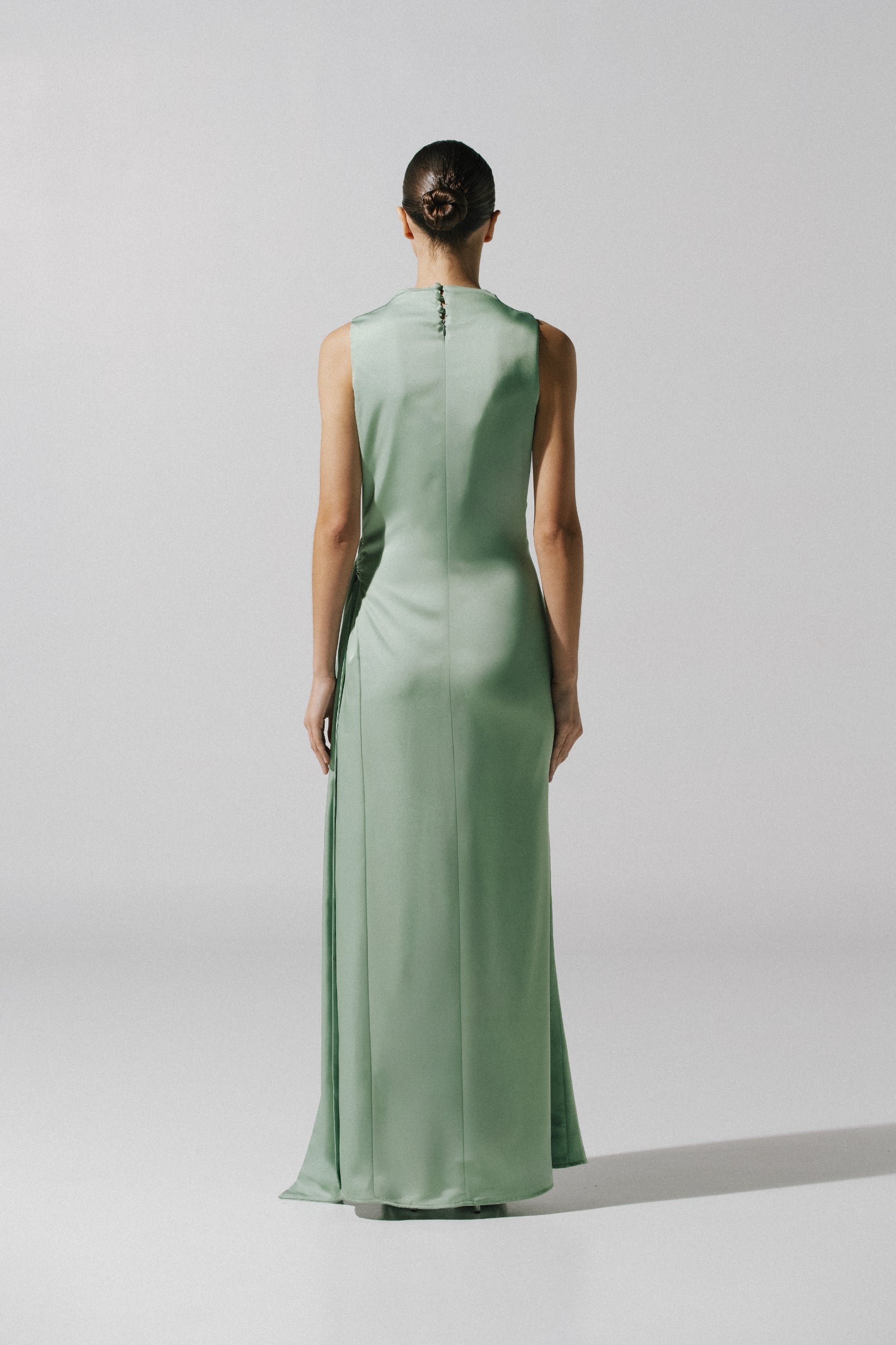 Back view of model wearing the Baobab Vitto Maxi Dress in Jade color, showing the Open back and Maxi length skirt.