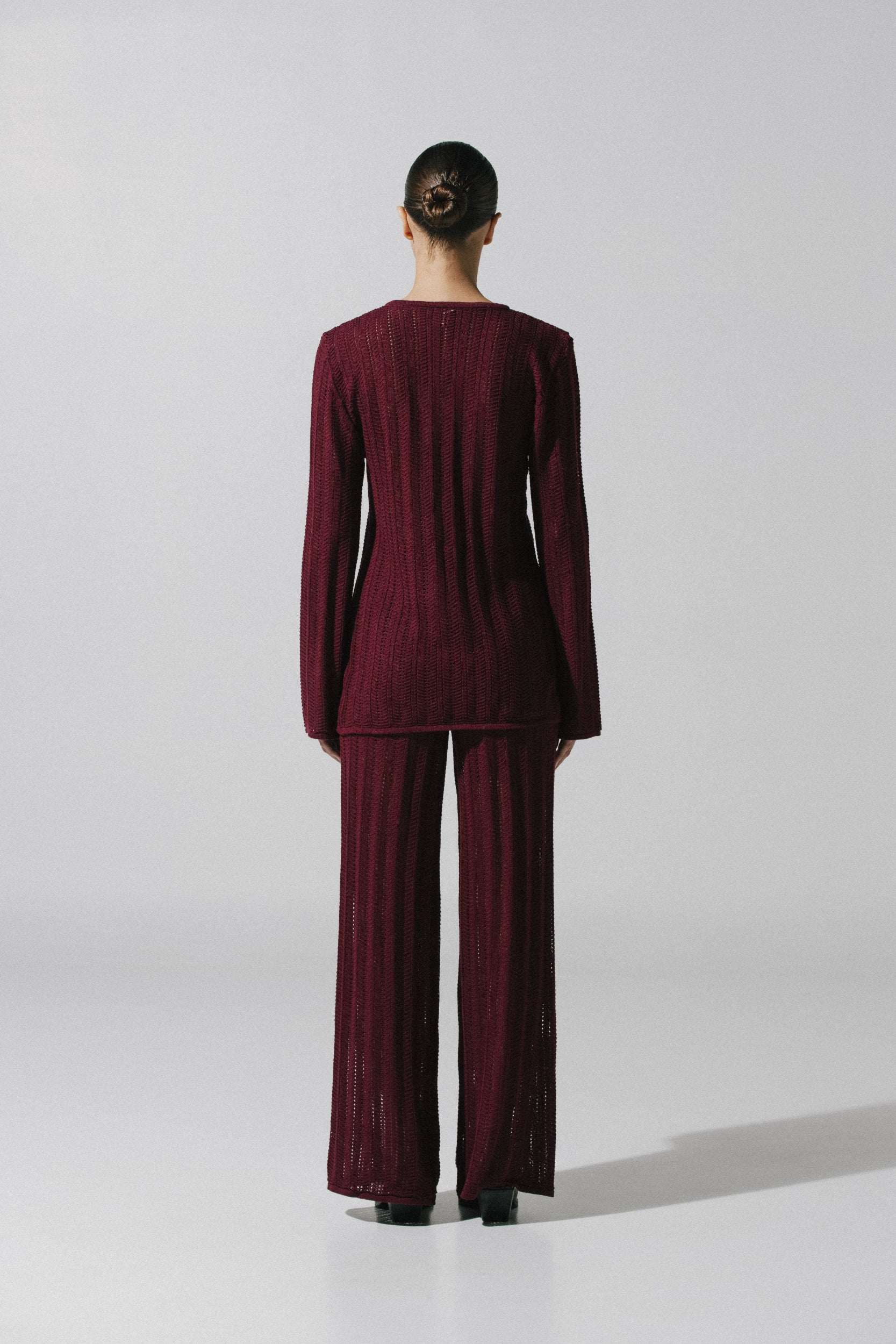 Detail of the Corsica Pants by Baobab, Semi-sheer knit fabric in burgundy color.