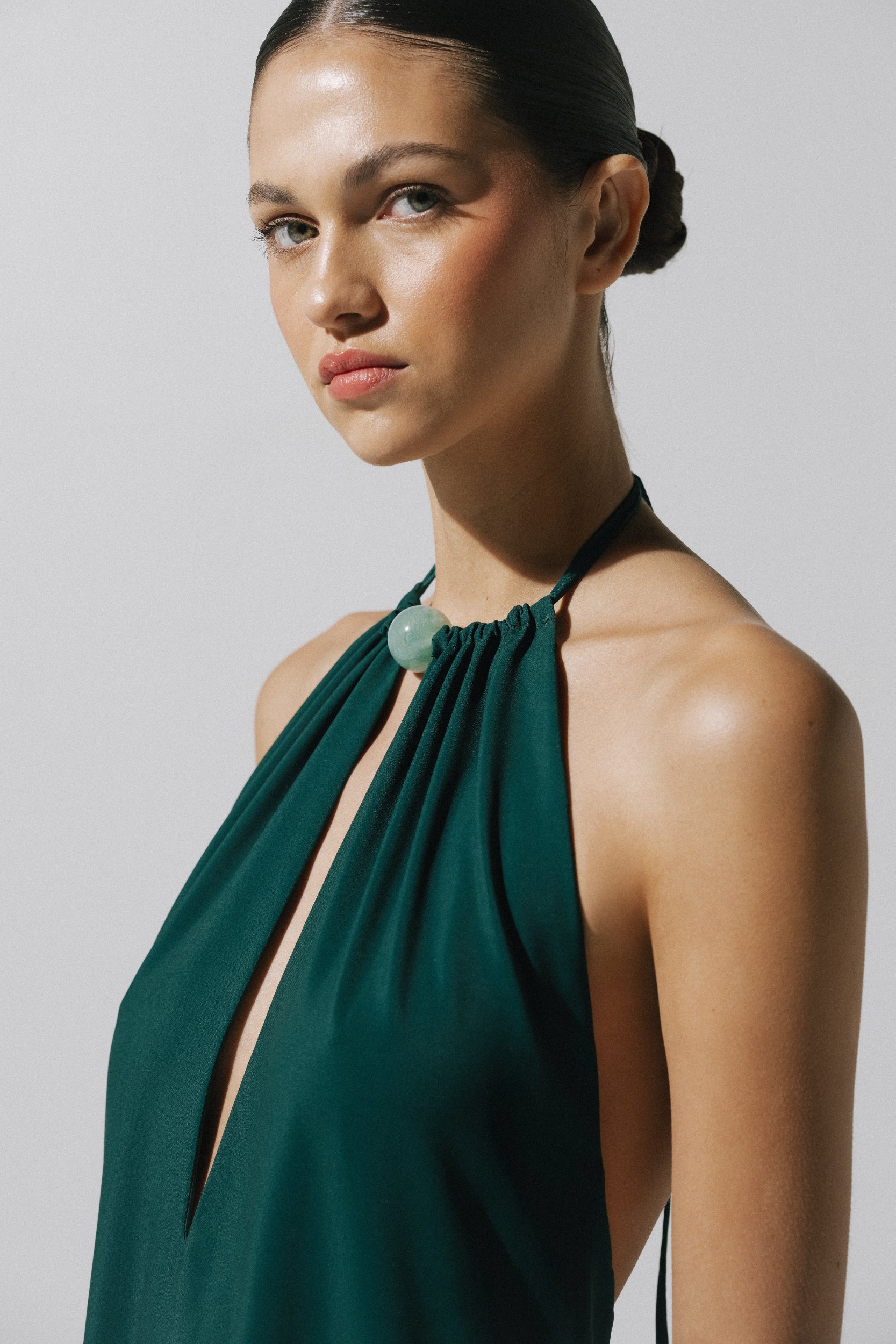 Emerald green Rondine Dress with Halter Neckline, fitted silhouette and Glossy fabric.